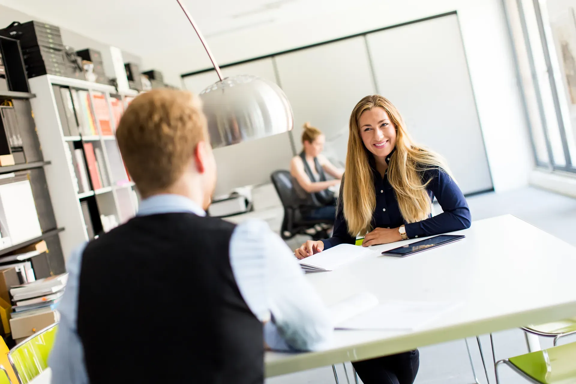 Beratungsgespräch an einem Schreibtisch in einem hellen Büro